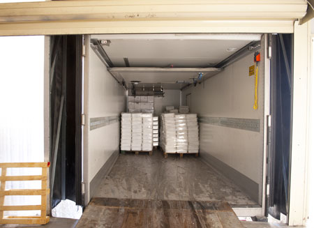 L T L freight is shown in the back of a truck as it sits at a loading dock.